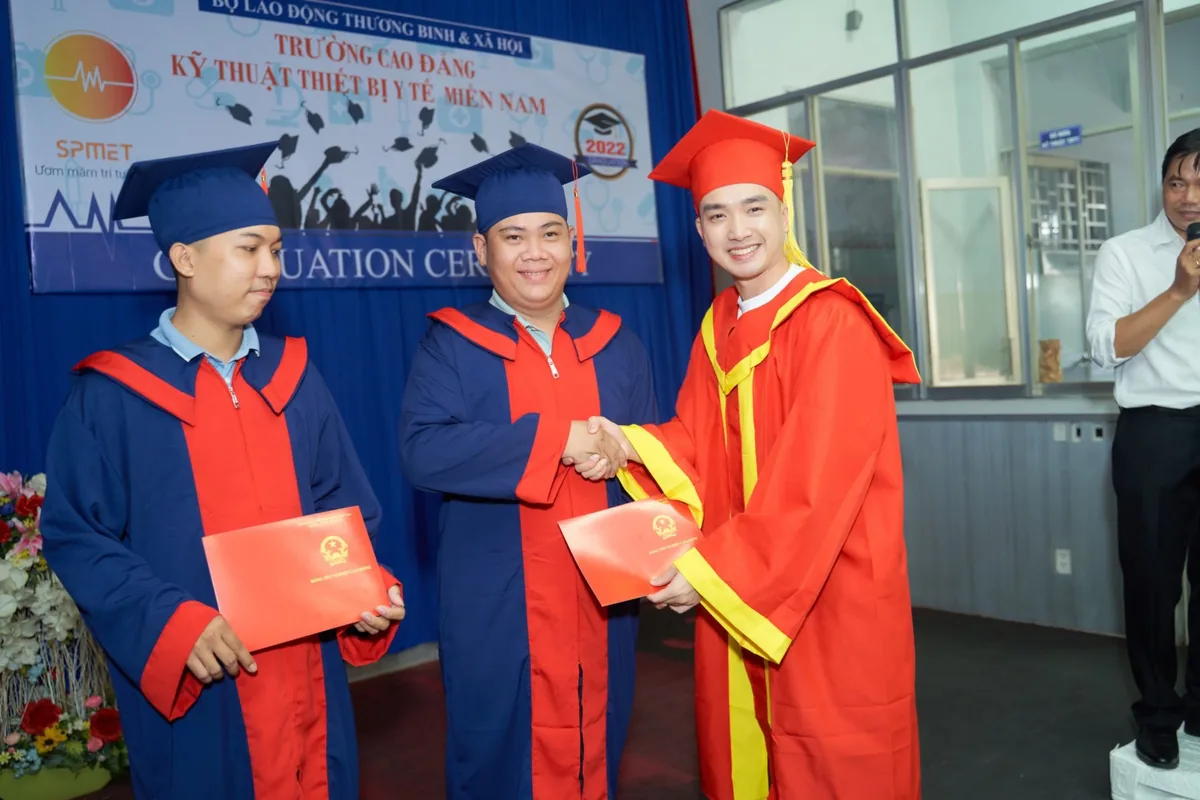 Sang Le handing a diploma to an SPMET graduate