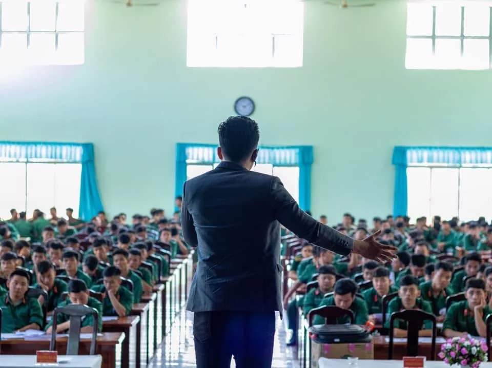 Sang Le speaking to a full hall of SPMET students